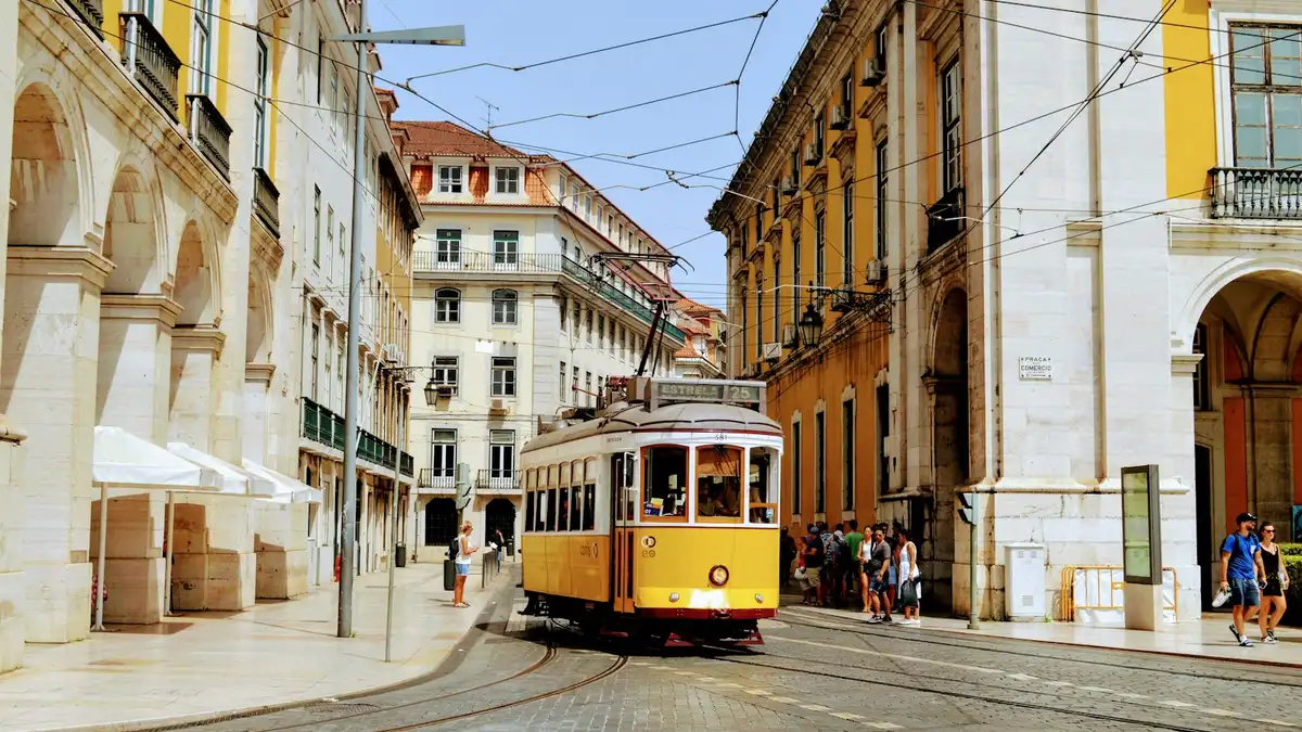 Tranvía amarillo 28 subiendo por una calle estrecha de Alfama Lisboa